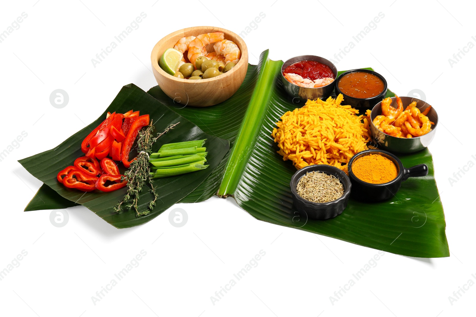 Photo of Piece of banana leaf with different food, spices and sauce isolated on white. Healthy eco serving