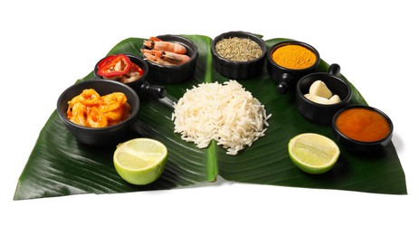 Photo of Cut banana leaf with different food, spices and sauce isolated on white. Healthy eco serving