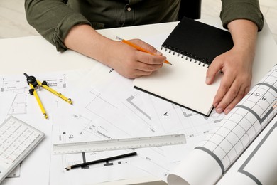 Photo of Architect working with project, closeup. Different technical drawings on white table