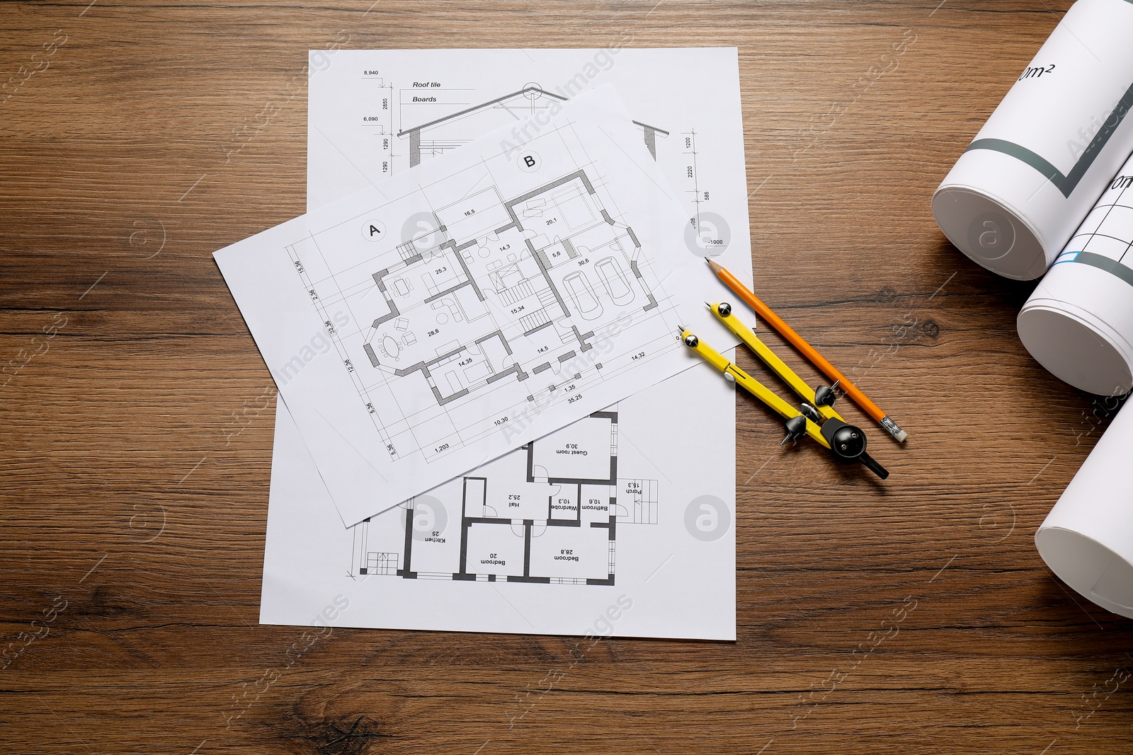 Photo of Different architectural drawings, pencil and divider on wooden table, flat lay