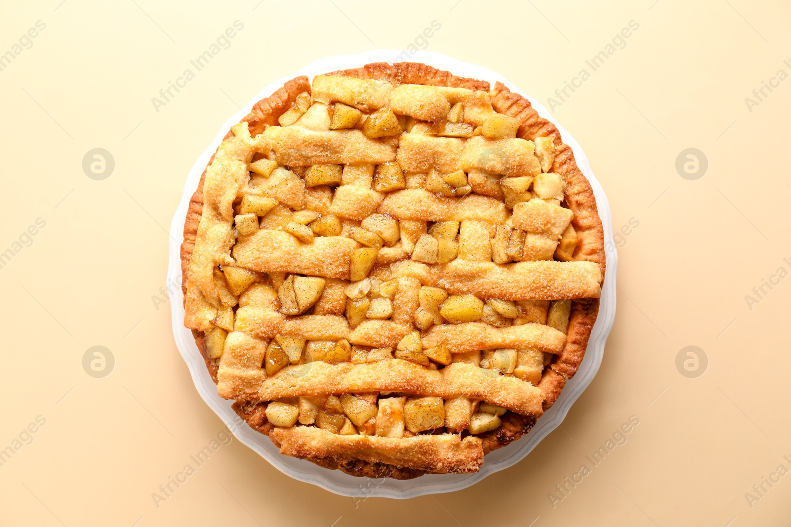 Photo of Tasty homemade apple pie on beige background, top view