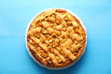 Photo of Tasty homemade apple pie on light blue wooden table, top view