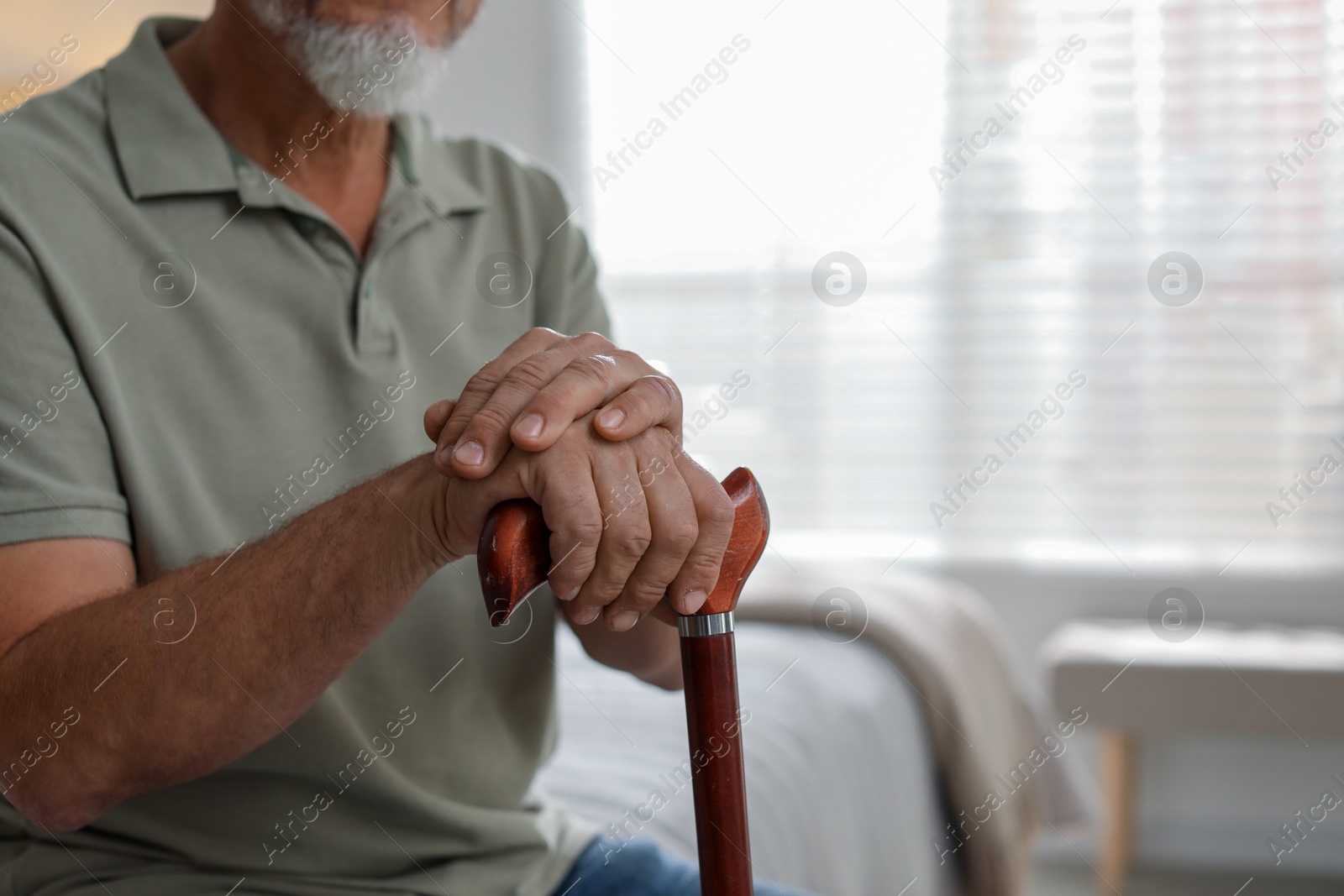 Photo of Lonely senior man with walking cane at home, closeup. Space for text