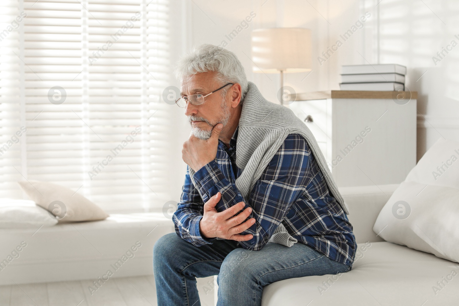 Photo of Lonely senior man sitting on sofa at home