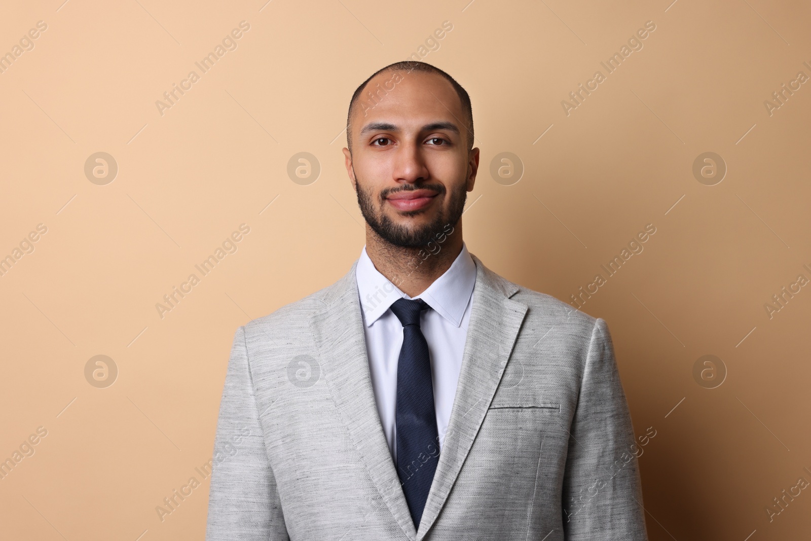 Photo of Portrait of businessman in jacket on beige background