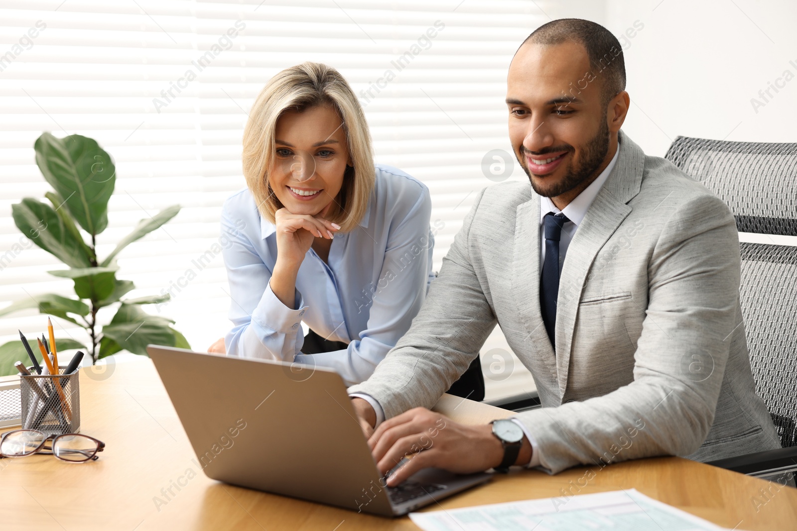 Photo of Coworkers with laptop working together in office