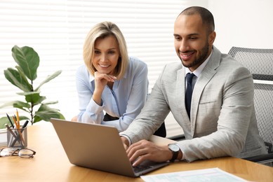 Photo of Coworkers with laptop working together in office