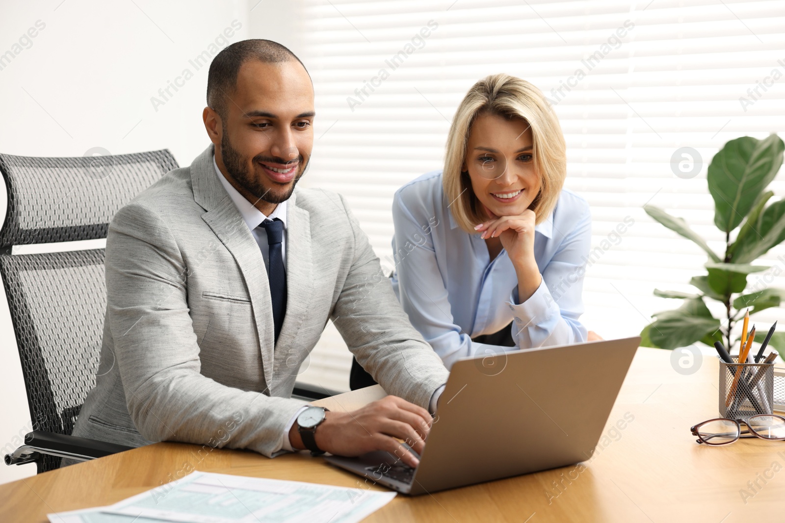 Photo of Coworkers with laptop working together in office