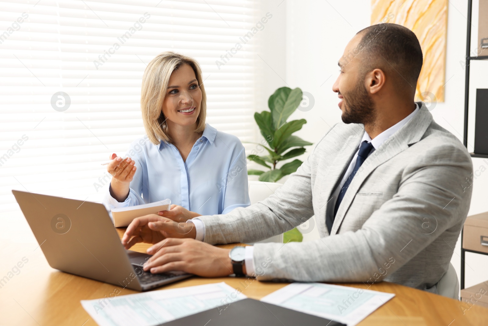 Photo of Coworkers with laptop working together in office