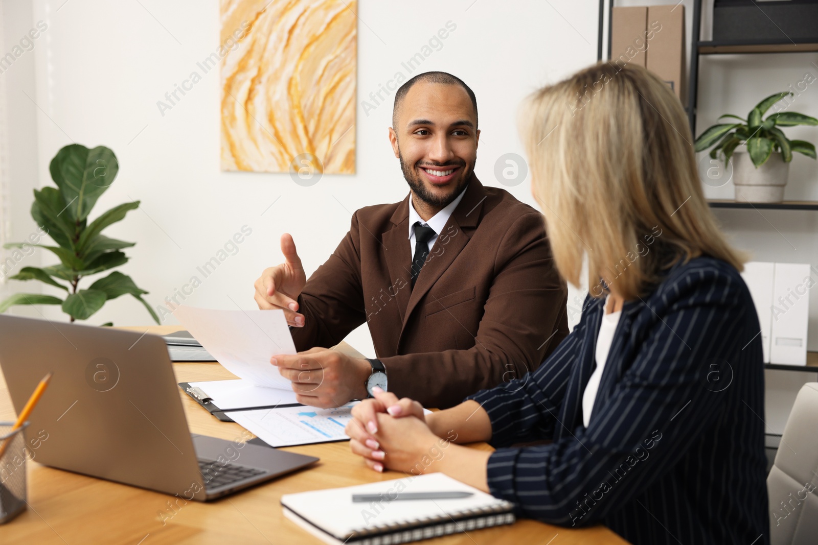 Photo of Coworkers working together at table in office