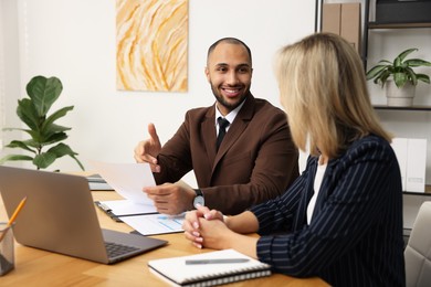 Photo of Coworkers working together at table in office