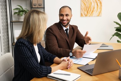 Photo of Coworkers working together at table in office