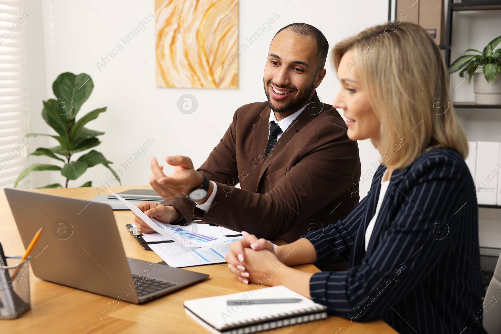 Photo of Coworkers working together at table in office