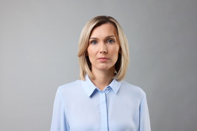 Photo of Portrait of businesswoman in light blue shirt on gray background