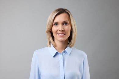 Photo of Portrait of happy businesswoman on gray background