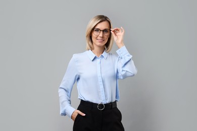 Photo of Portrait of businesswoman in glasses on gray background