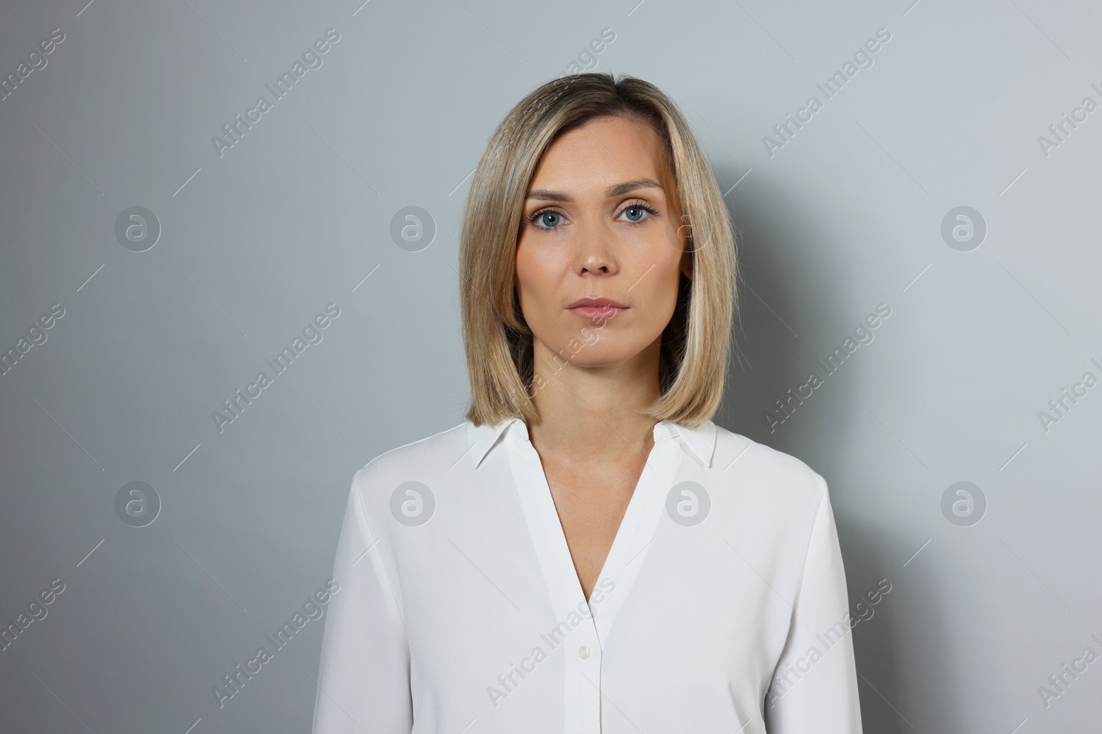 Photo of Portrait of businesswoman in white shirt on gray background