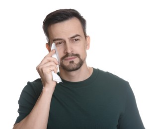 Photo of Sad man with paper tissue crying on white background