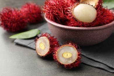 Photo of Delicious ripe rambutans on grey table, closeup