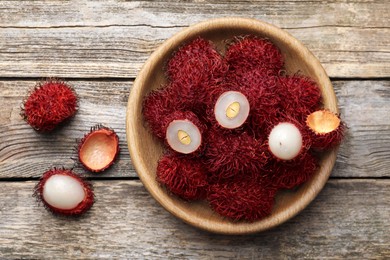 Photo of Delicious ripe rambutans on wooden table, top view