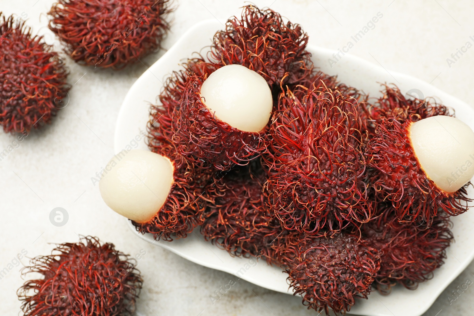 Photo of Delicious ripe rambutans on light grey table, top view