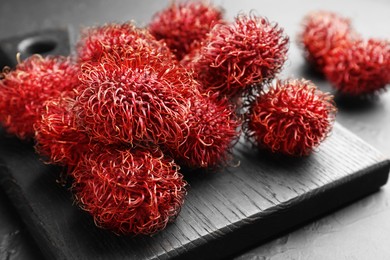 Photo of Delicious ripe rambutans on black table, closeup