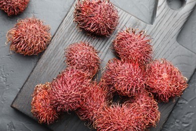 Photo of Delicious ripe rambutans on black table, top view