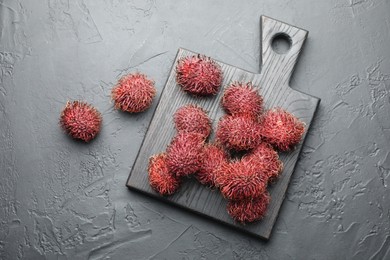 Photo of Delicious ripe rambutans on black table, top view