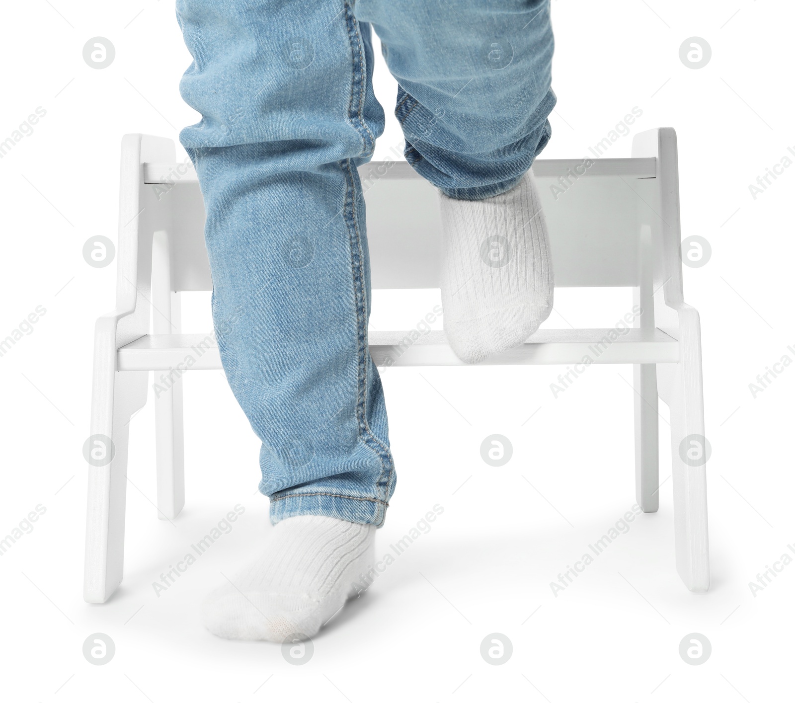 Photo of Little boy with step stool against white background, closeup