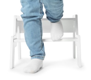 Photo of Little boy with step stool against white background, closeup