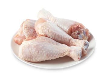 Photo of Raw chicken drumsticks on plate against white background