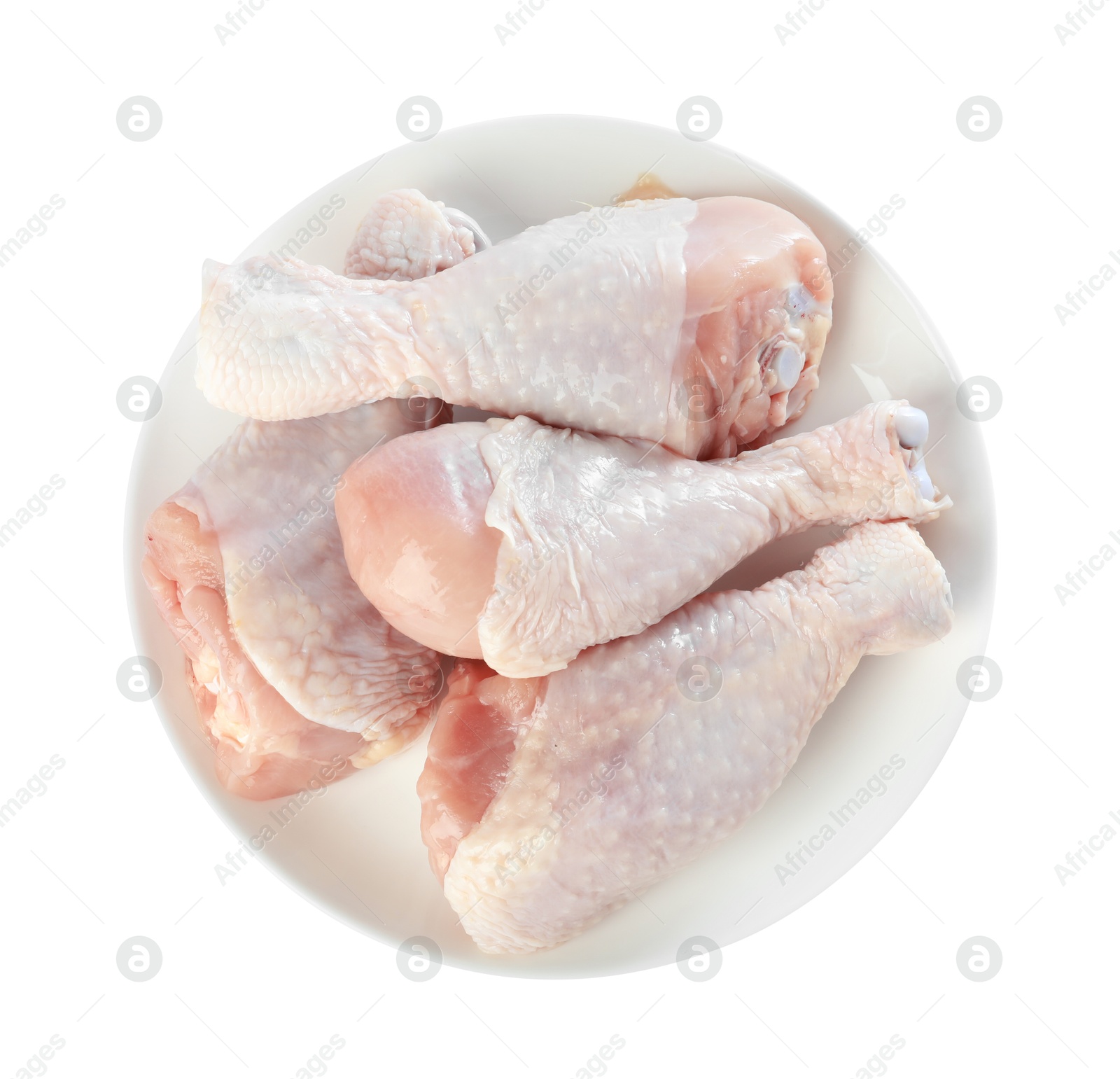 Photo of Raw chicken drumsticks on plate against white background, top view