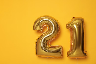 Photo of Coming of age party - 21st birthday. Number shaped balloons on orange background