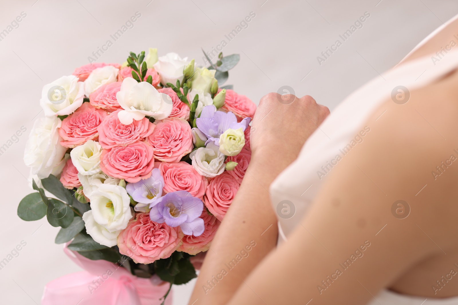 Photo of Bride with beautiful wedding bouquet on light background, closeup