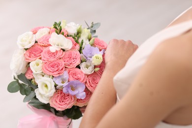 Photo of Bride with beautiful wedding bouquet on light background, closeup