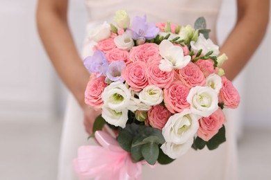 Photo of Bride with beautiful wedding bouquet on light background, closeup