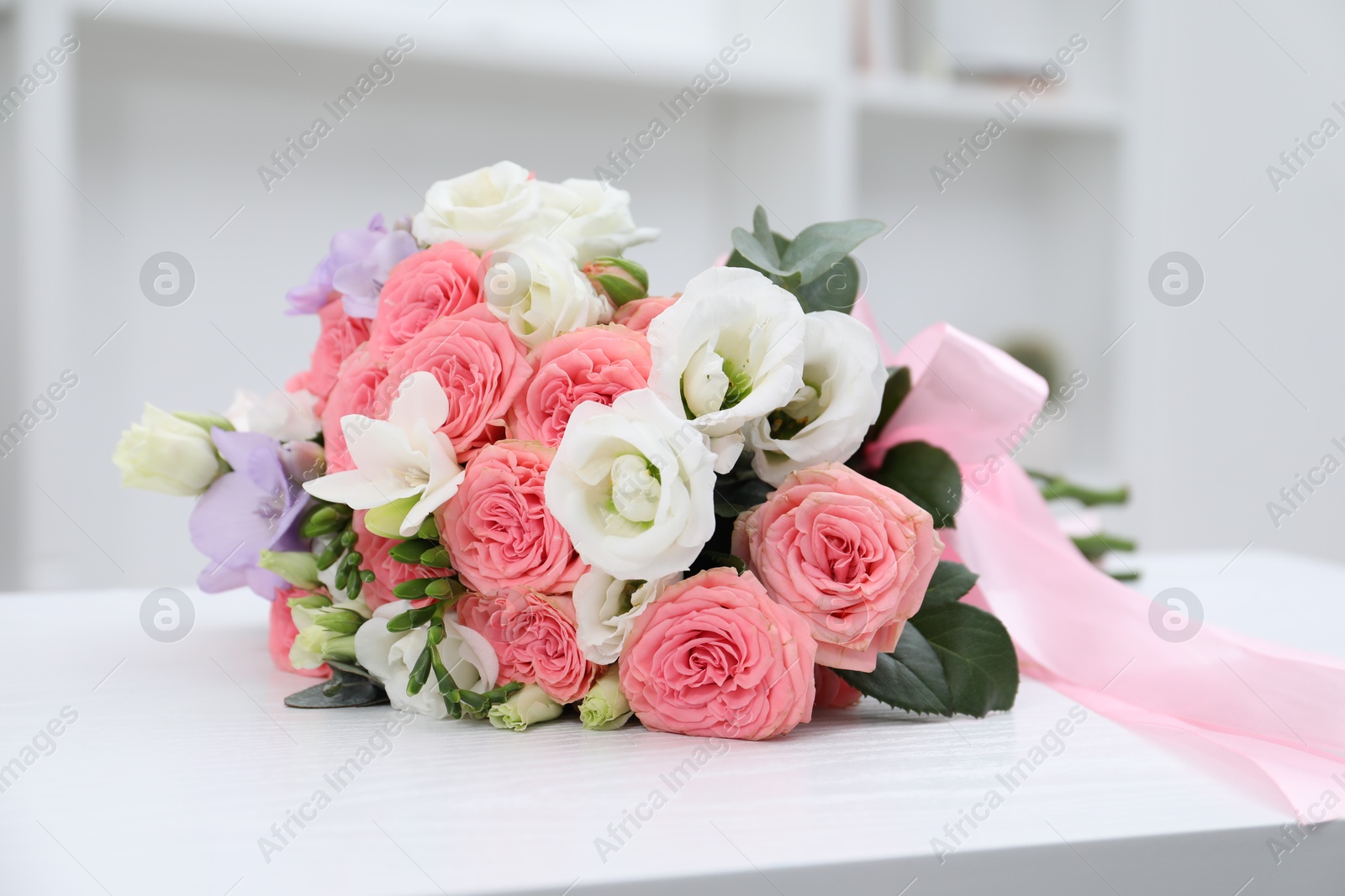 Photo of Beautiful wedding bouquet on white table indoors, closeup