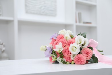 Photo of Beautiful wedding bouquet on white table indoors, space for text