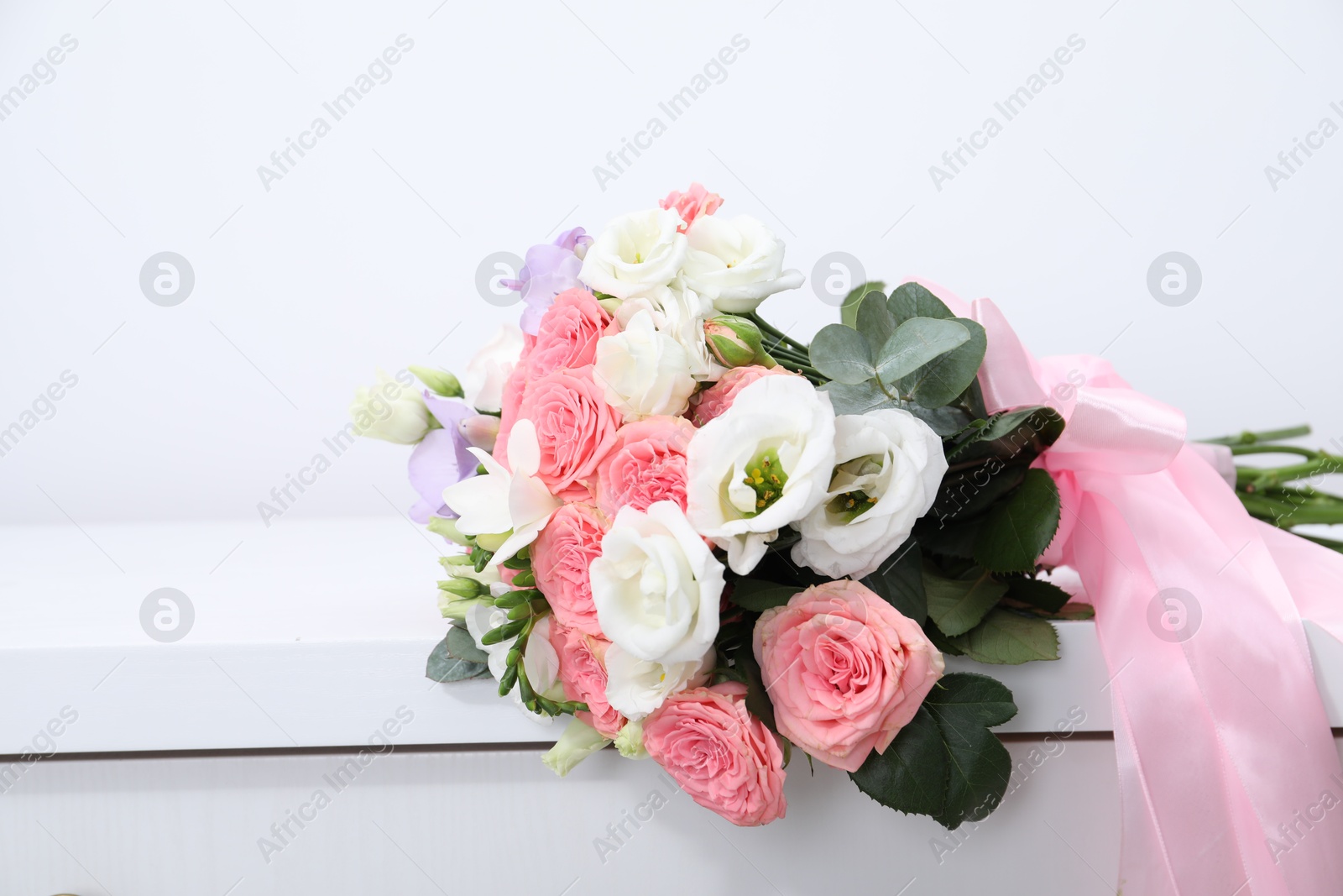 Photo of Beautiful wedding bouquet on white table, closeup. Space for text