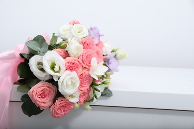 Photo of Beautiful wedding bouquet on white table, closeup. Space for text