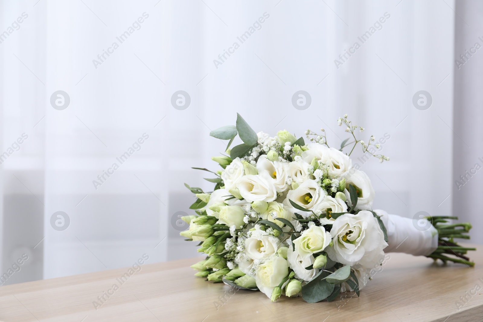 Photo of Beautiful wedding bouquet on wooden table, space for text