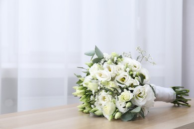 Photo of Beautiful wedding bouquet on wooden table, space for text