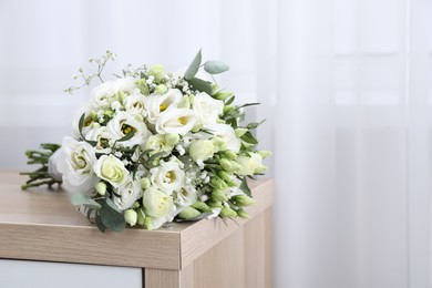 Photo of Beautiful wedding bouquet on wooden nightstand indoors, space for text