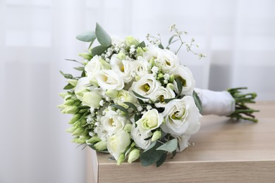 Photo of Beautiful wedding bouquet on wooden table indoors