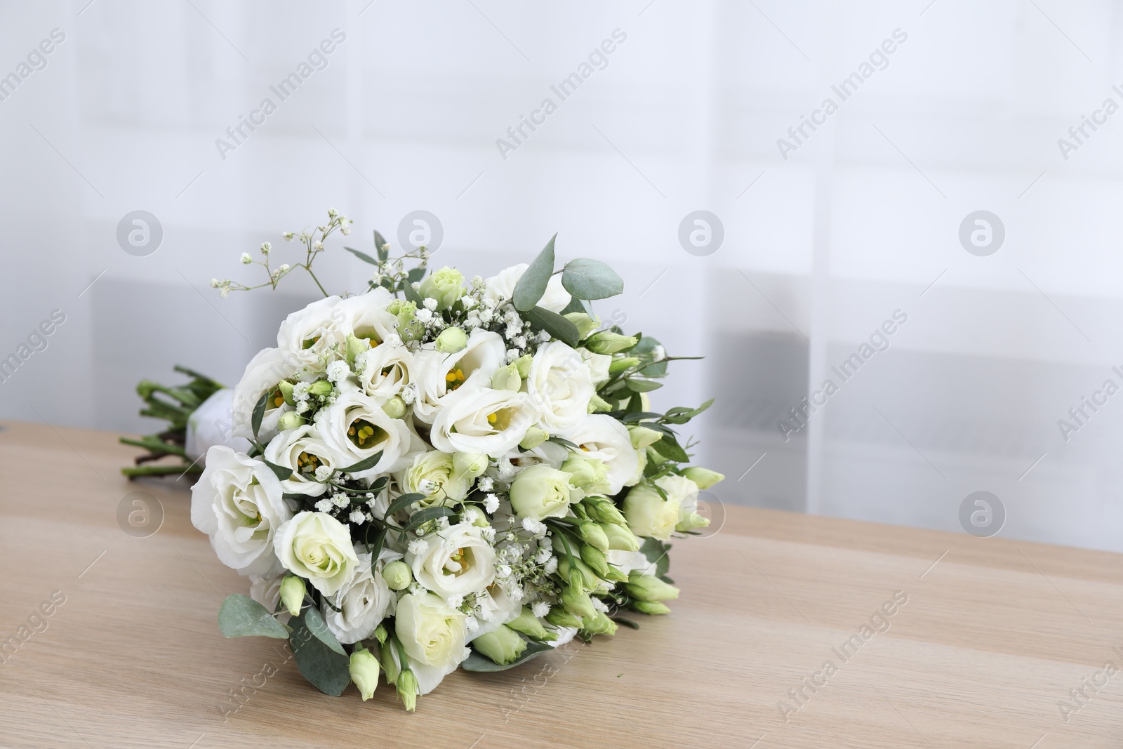 Photo of Beautiful wedding bouquet on wooden table, space for text