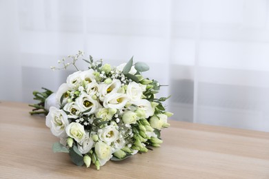 Photo of Beautiful wedding bouquet on wooden table, space for text