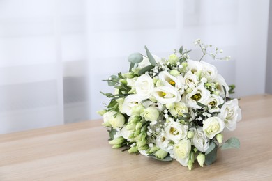 Photo of Beautiful wedding bouquet on wooden table, space for text