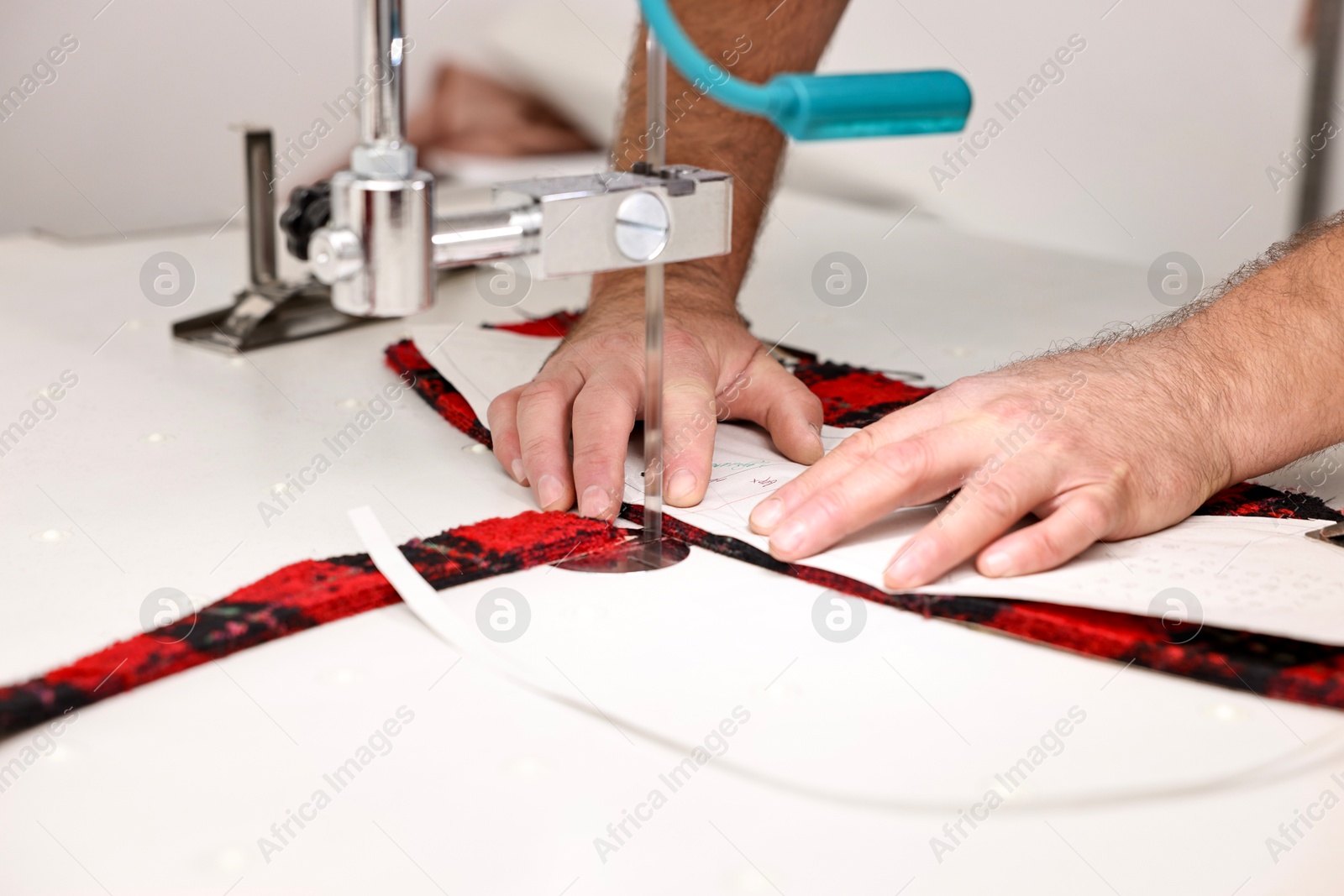 Photo of Man working at white table in professional workshop, closeup