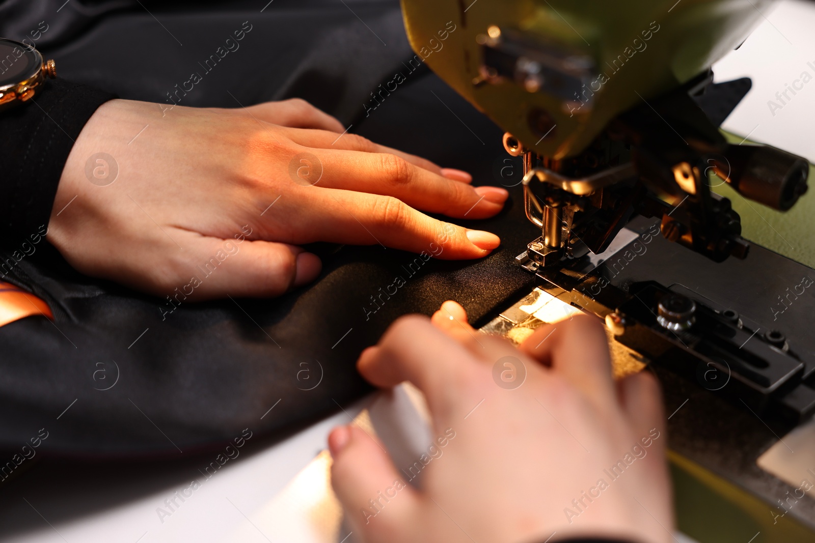 Photo of Woman working with sewing machine in professional workshop, closeup