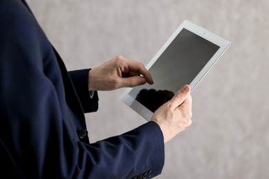 Photo of Businessman using tablet indoors, closeup. Modern technology